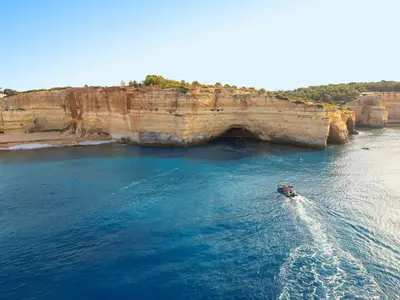 a boat in the water next to a cliff at Villa Saint Lucia by Algarve Vacation in Albufeira