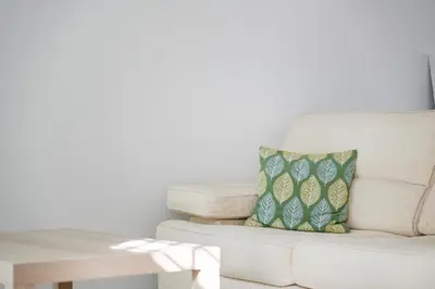 a white couch with a pillow on it next to a table at Casa do Avô - Faro City in Faro