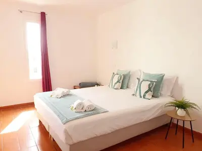 a bedroom with a large white bed with towels on it at Apartamento do Moinho acesso à Piscina in Albufeira
