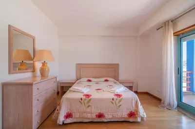 a bedroom with a bed and a dresser and a mirror at Marina de Albufeira by Garvetur in Albufeira