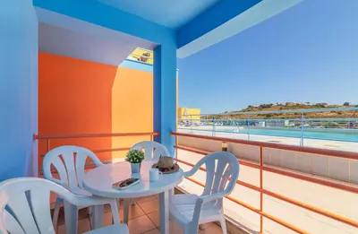 a table and chairs on a balcony with a view of the beach at Marina de Albufeira by Garvetur in Albufeira