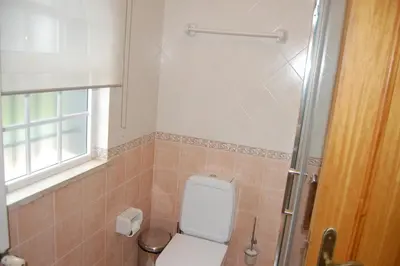 a bathroom with a toilet and a window and a shower at Charmante Villa mit 3 Schlafzimmer und Blick zum Meer in Santa Bárbara de Nexe