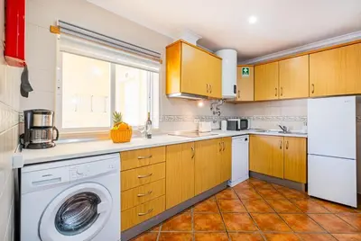 a kitchen with a washing machine and a window at Cosy apartment in Jardins Vale de Parra in Guia