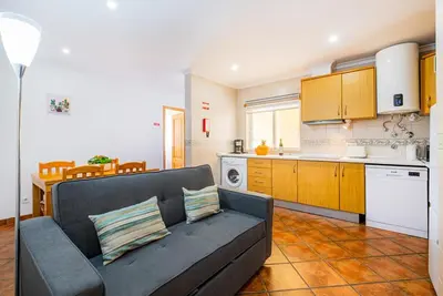 a living room with a couch and a kitchen at Cosy apartment in Jardins Vale de Parra in Guia