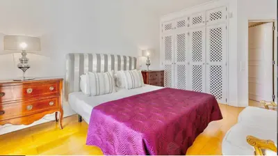 a bedroom with a bed and a dresser with a purple blanket at Sandnblue - Encosta Do Lago Resort Club - Quinta do lago near Beach & lake BEST LOCATION in Quinta do Lago
