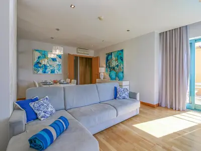 a living room with a gray couch and blue pillows at Luxury 1 Bedroom Apartment, Marina de Albufeira in Albufeira