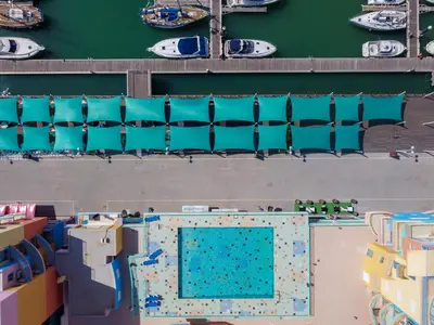 an overhead view of a swimming pool with blue chairs at Luxury 1 Bedroom Apartment, Marina de Albufeira in Albufeira