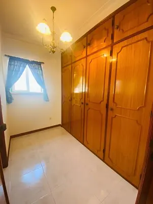a room with wooden cabinets and a window at Moradia VSSG em Vilamoura in Quarteira