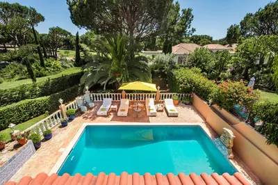 a patio with a table and chairs next to a pool at 4 Bedrooms Private Pool Close To All Amenities in Quarteira