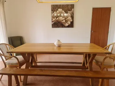 a wooden table with chairs and a vase on top at Casa dos Arcos in Olhos de Água