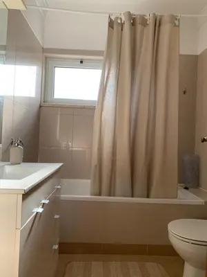 a bathroom with a shower curtain and a toilet at Galé Garden House in Guia