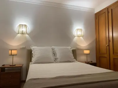 a bedroom with a bed with two lights on it at Galé Garden House in Guia