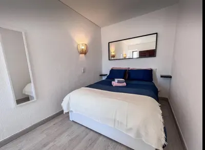 a bedroom with a bed with blue pillows and a mirror at Sea View One Bedroom with Swimming Pool Ponce 282 in Albufeira