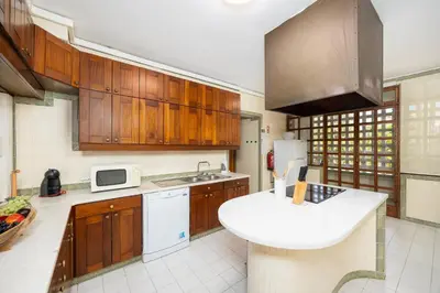 a kitchen with wooden cabinets and a sink at Villa Mexico in Quarteira