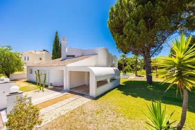 a white house with trees and a yard at Villa Mexico in Quarteira