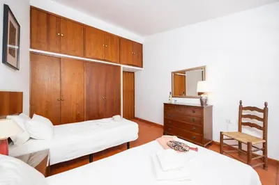 a bedroom with two beds and a chair in it at Villa Mexico in Quarteira