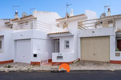 a large white house with two garage doors at #229 Quinta das Areias by Home Holidays in Albufeira