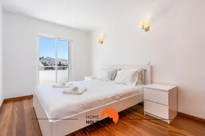 a white bedroom with a bed and a window at #229 Quinta das Areias by Home Holidays in Albufeira
