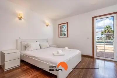 a white bedroom with a bed and a window at #229 Quinta das Areias by Home Holidays in Albufeira