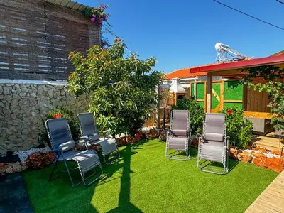 a group of chairs sitting on the grass in a yard at Casa de Aloe in Albufeira