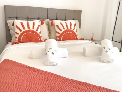 a bedroom with a large bed with yellow and white pillows at Riamar House - Faro City Center in Faro