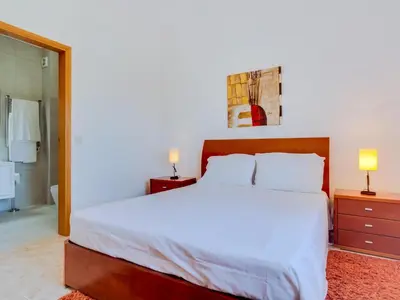 a bedroom with a large white bed and two lamps at AL Casa Raha in Quinta do Lago