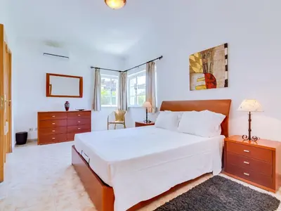 a bedroom with a large white bed and two dressers at AL Casa Raha in Quinta do Lago