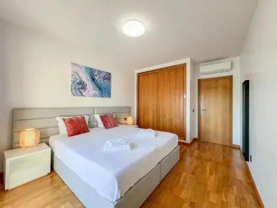 a bedroom with a large white bed with red pillows at Fantastic Villa, Private Pool, BBQ, AC and Wi-Fi in Quarteira
