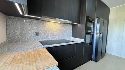 a kitchen with black cabinets and a wooden counter top at Fantastic Villa, Private Pool, BBQ, AC and Wi-Fi in Quarteira