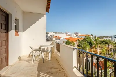 a balcony with tables and chairs and a view at Appartement Albufeira in Albufeira