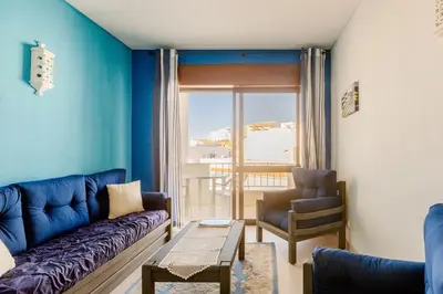 a blue living room with a couch and a chair at Appartement Albufeira in Albufeira