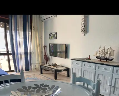 a living room with a glass table and a wooden model ship at Appartement Albufeira in Albufeira