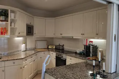 a kitchen with white cabinets and granite counter tops at Private luxury apartment Vale do Lobo in Almancil