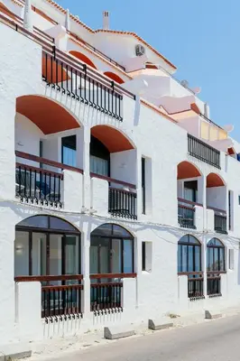 a white building with windows and balconies at MUPA Apartments in Albufeira