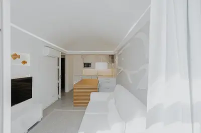 a kitchen with white cabinets and a white wall at MUPA Apartments in Albufeira