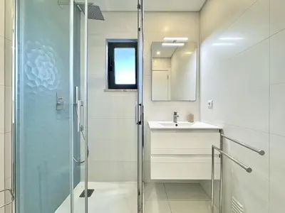 a bathroom with a glass shower and a sink at Faro Prestige by Homing in Faro