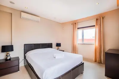 a bedroom with a large bed and a window at Capetown Marina Luxury Villa - Private Pool in Albufeira