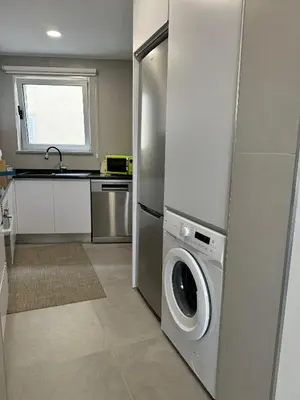 a kitchen with a refrigerator and a washing machine at Marina Gemeos - Vilamoura Center by HD Properties in Vilamoura
