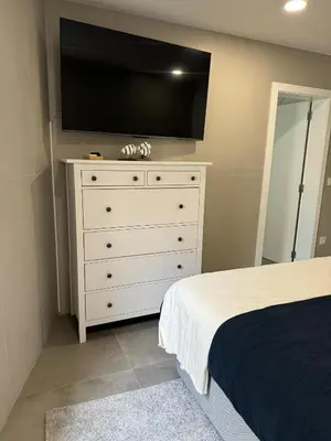 a bedroom with a dresser with a flat screen tv on the wall at Marina Gemeos - Vilamoura Center by HD Properties in Vilamoura
