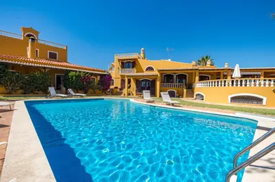 a swimming pool in front of a house at Villa Sobreiro in Albufeira