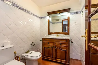 a bathroom with a toilet and a sink and a mirror at Villa Sobreiro in Albufeira
