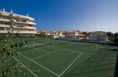 a tennis court in front of a apartment building at Stylish 2BR Apartment with Pool Parking & WiFi in Albufeira
