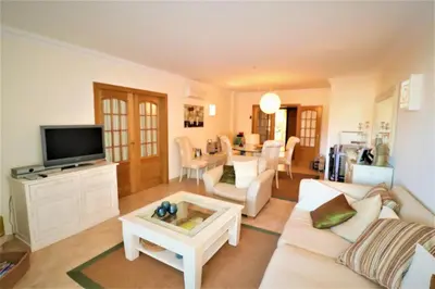 a living room with a white couch and a tv at Stylish 2BR Apartment with Pool Parking & WiFi in Albufeira