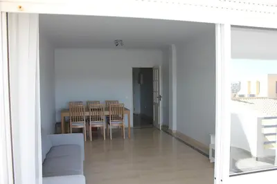 a living room with a table and a dining room at Vilamoura 10 in Quarteira