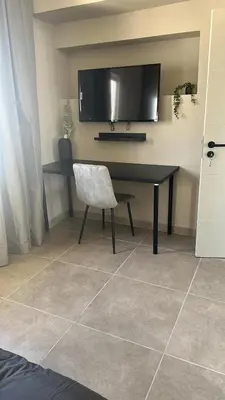 a desk with a chair and a television on a wall at Vilamoura in Quarteira