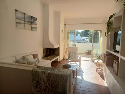 a kitchen and dining room with a white table and chairs at Villa Blue - Aldeia do Golfe in Quarteira