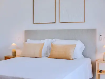 a bedroom with a white bed with two pillows at AL Apartamento Alsol in Quarteira