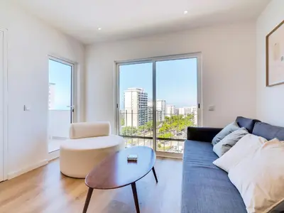 a living room with a blue couch and a table at AL Apartamento Alsol in Quarteira
