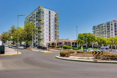 an empty street in a city with tall buildings at AL Apartamento Alsol in Quarteira