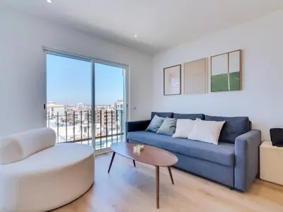 a living room with a blue couch and a table at AL Apartamento Alsol in Quarteira